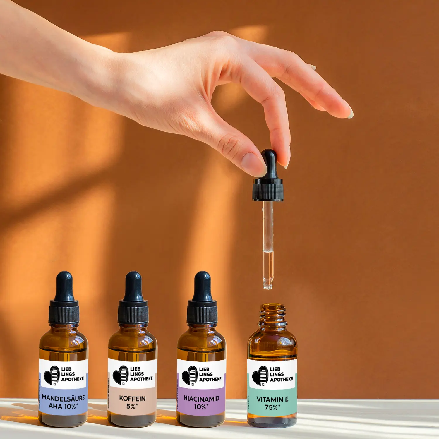 Frauenhand_haelt_eine_Pipette_ueber_einem_geoeffneten_Flaeschchen_mit_konzentriertem_Aktivstoff_daneben_stehen_noch_3_weitere_geschlossene_Flaeschchen